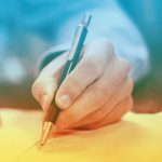 close up of man's hand writing