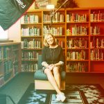 Woman sitting in chari in front of bookcase