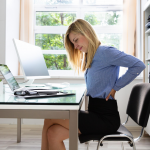 Woman sitting at desk with back pain